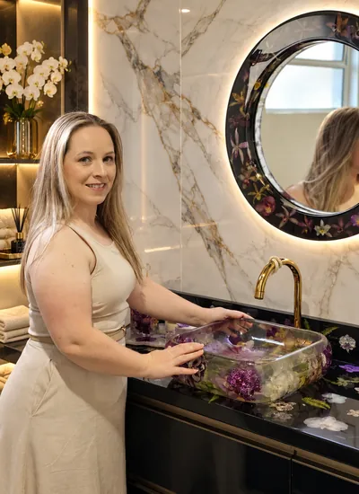 Ana num banheiro com cuba e espelho de resina com flores